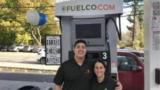 Danny Elijamal and his mother in front of a Fuelco gas pump