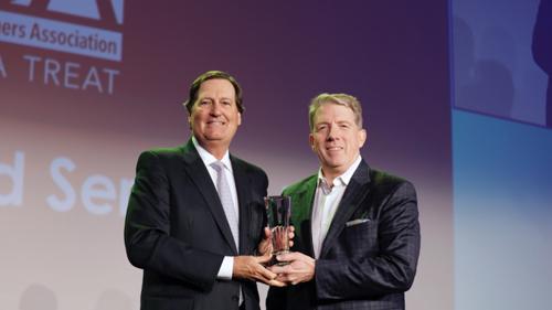Jerry Hagedorn, executive vice president of business development for Barry Callebaut USA LLC, accepts the NCA's 2018 Distinguished Service Award from NCA President and CEO John Downs Jr. (left).