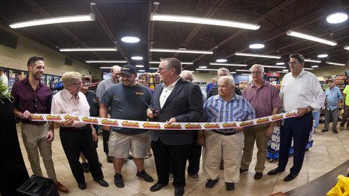 Rutter's President and CEO Scott Hartman prepares to cut the ribbon at grand opening of chain's largest store to date, in front of family members, company associates and customers.