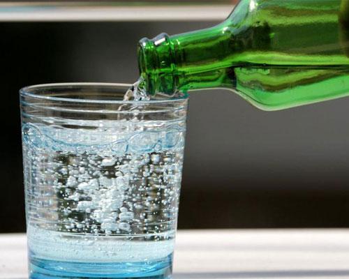 pouring sparkling water into glass