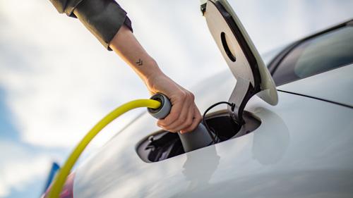 A person charging an electric vehicle
