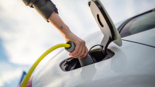 A person charging an electric vehicle
