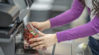 A woman uses self checkout