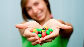 Young woman holding a handful of candy