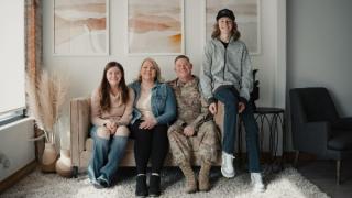 Military service member and their family sitting on a sofa
