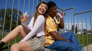 Two girls sitting back-to-back and drinking Joyba Bubble Tea