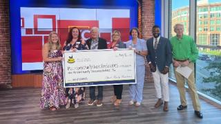Spinx representatives present a donation check