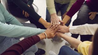 A group of people putting their hands in together