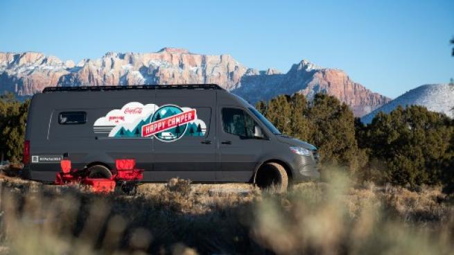 Maverik & Coke Custom Happy Camper Van parked in front of a mountain range