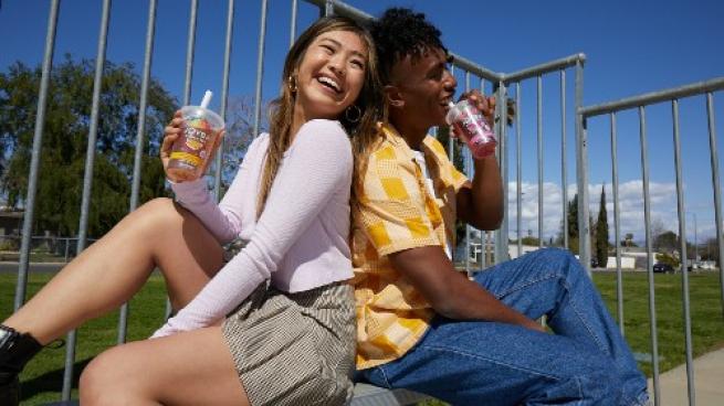 Two girls sitting back-to-back and drinking Joyba Bubble Tea