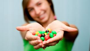 Young woman holding a handful of candy