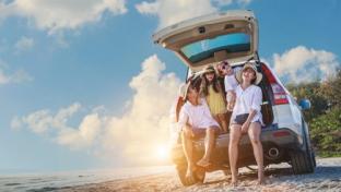 Family in car on road trip, stopped on a beach