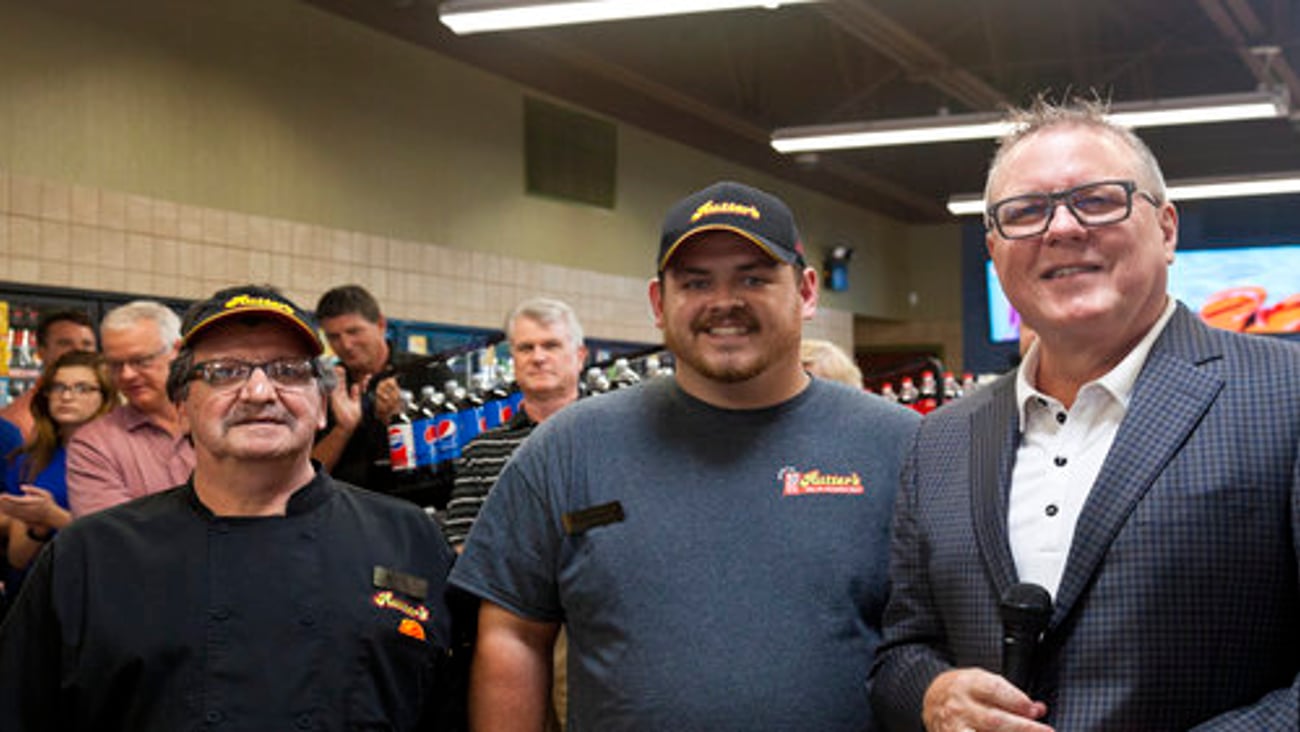 Hartman introduces restaurant manager Joseph Mirasola (left) and store manager Andrew Ewing at the grand opening ceremony.