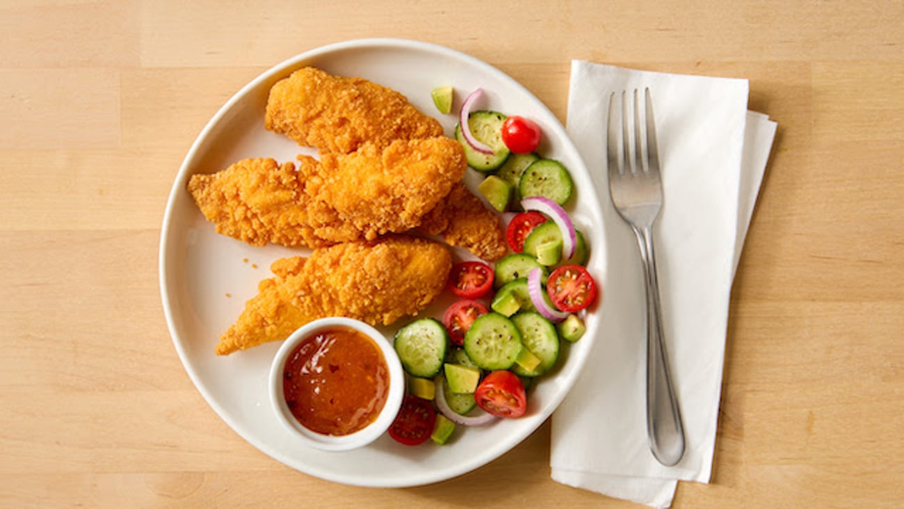 Tyson Gluten Free Fully Cooked Breaded Chicken Tenderloins on a plate with a salad and dipping sauce