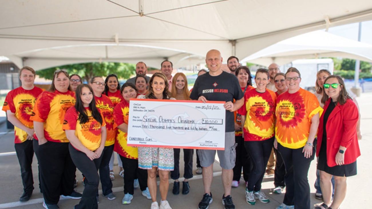 The OnCue team presents a check to the Special Olympics
