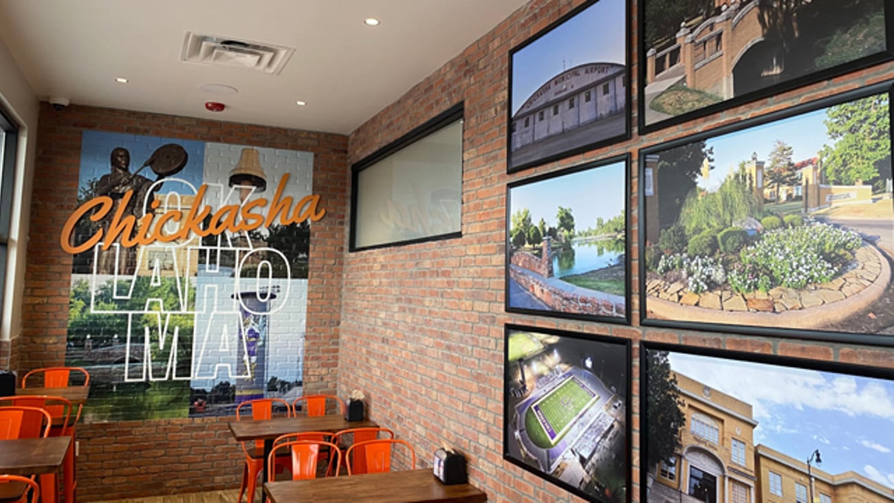 The interior seating section of a Roasters convenience stores with local photos on the wall