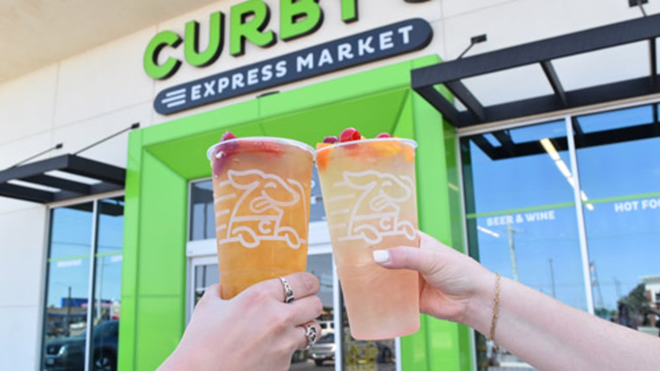 Customers drinking dispensed drinks outside of Curby's Express Market