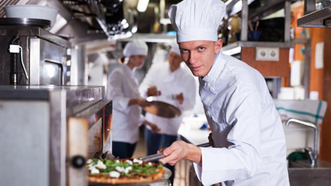 A chef making a pizza