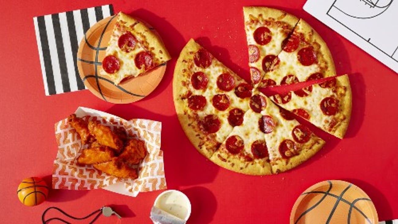 7-Eleven pizza and hot wings served on basketball styled paper plates