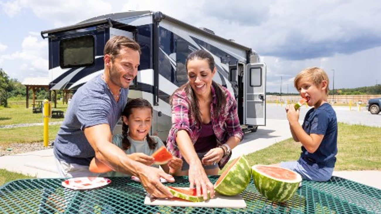 Family eating watermelon at picnic table in front of RV at a Love's RV Stop 
