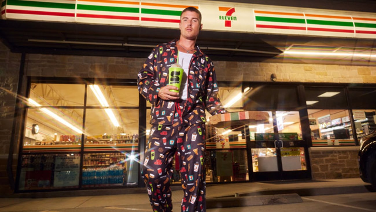 A man wearing 7-Eleven pajamas outside a 7-Eleven convenience store