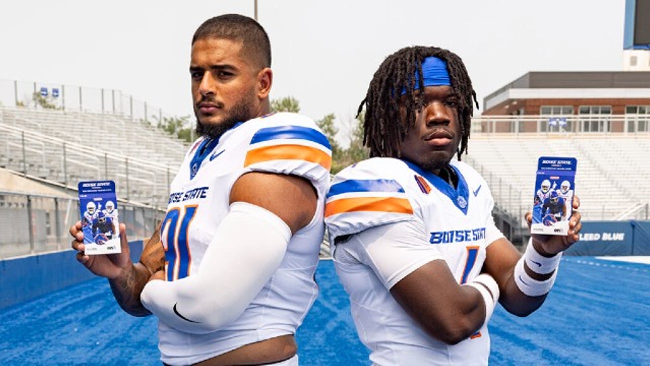 BSU football players holding trading card sets from Jacksons