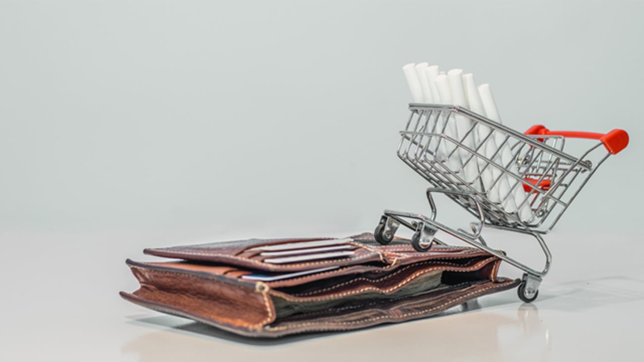 A shopping cart with cigarettes and a wallet