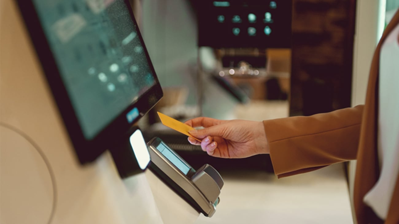 A woman using her credit card at a self-service payment kiosk