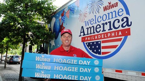 Wawa employee holding hoagies for Wawa Welcome America!