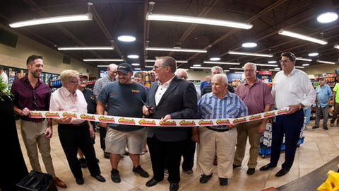 Rutter's President and CEO Scott Hartman prepares to cut the ribbon at grand opening of chain's largest store to date, in front of family members, company associates and customers.