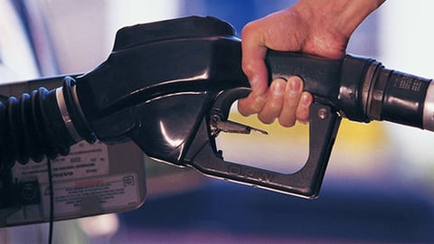 A motorist filling up at a gas station