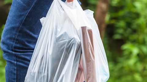 A shopper with single-use plastic bags