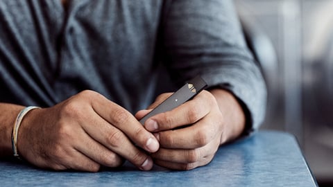 A person holding a Juul device