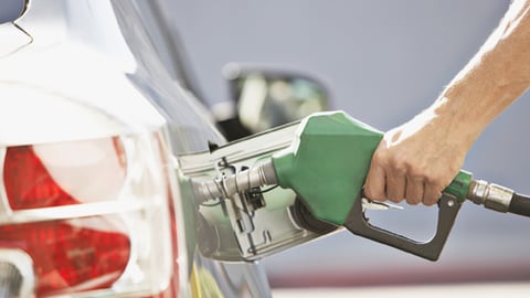 A person pumping gas at a gas station