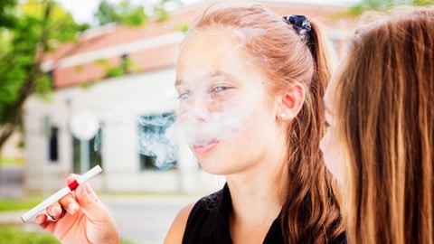 An underage girl using an electronic cigarette