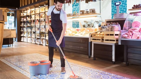 A retail employee mopping the floor