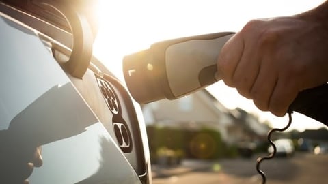 Hand plugging in electric vehicle charger