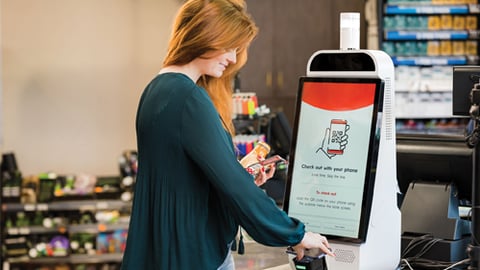 A women using a Grabango checkout kiosk