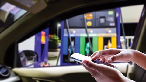 A motorists using a mobile app at the fuel pump