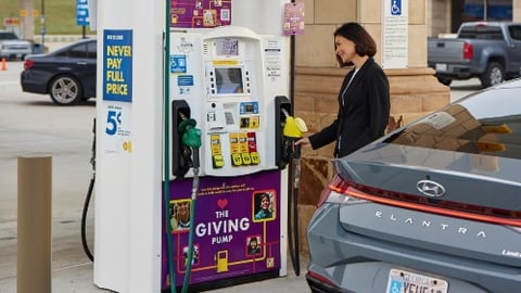 Woman using a Giving Pump at a Shell gas station