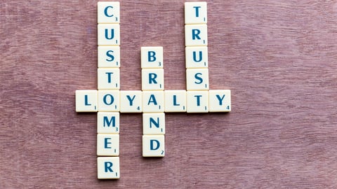 Scrabble tiles spell out customer, loyalty, trust and brand