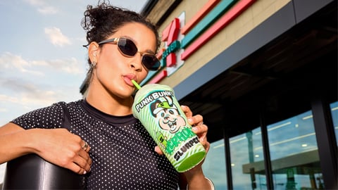 A female 7-Eleven customer drinking a Kerplunk Kandy Grape Slurpee