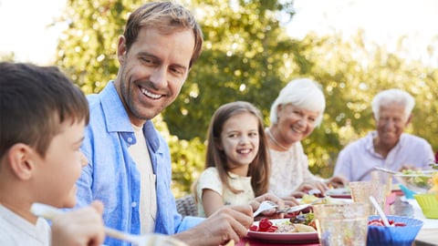 A multigenerational family eating a meal outside