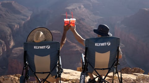 Two people in chairs taking in a mountain view while drinking fountain drinks