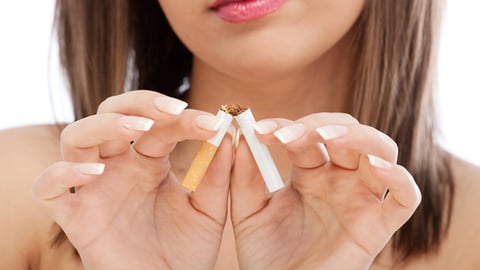 A female breaking a cigarette