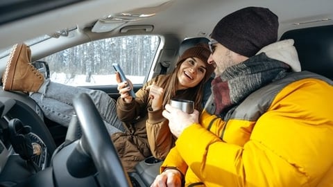 Man and women in winter clothing sitting in a car