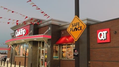 A Safe Place sign on a telephone pole outside a QuikTrip store