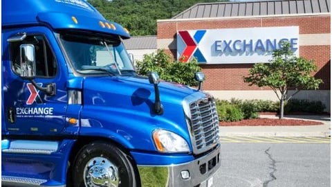 A blue tractor trailer in front of a Military Exchange Service store