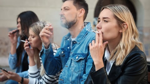 A group of adults outside smoking