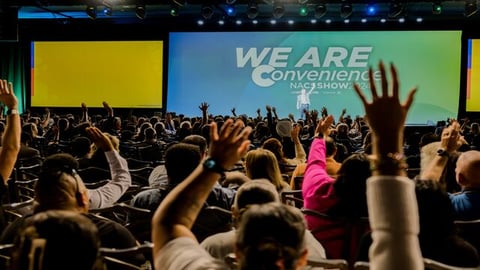 Audience members raising their hands at the general session at the NACS Show on Oct. 8